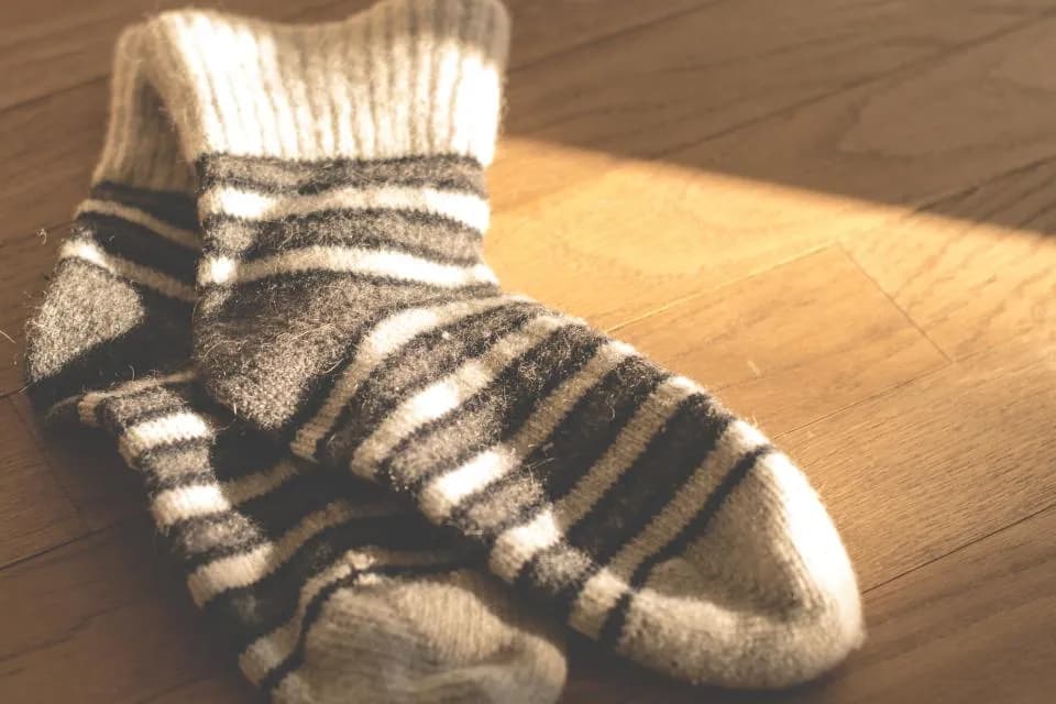 A pair of striped knitted socks on a wooden floor