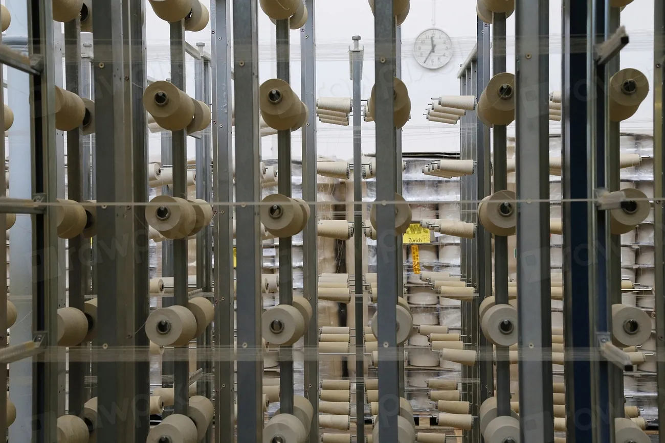 Rows of yarn cones on spinning frames in a textile mill
